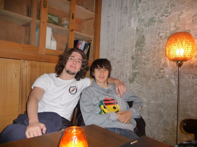Dos amigos sentados junto a una lámpara de luz cálida